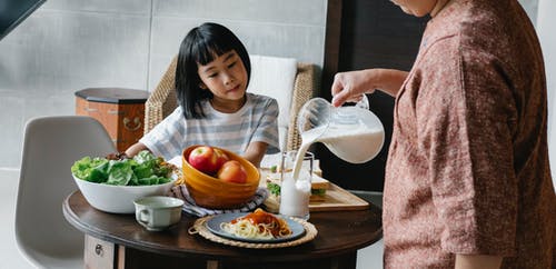 作物女人倒牛奶的小女孩 · 免费素材图片