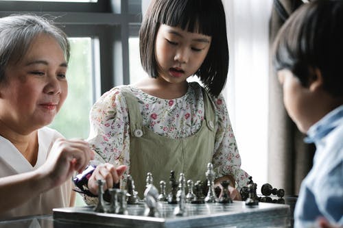 重点突出的孩子和祖母下棋 · 免费素材图片