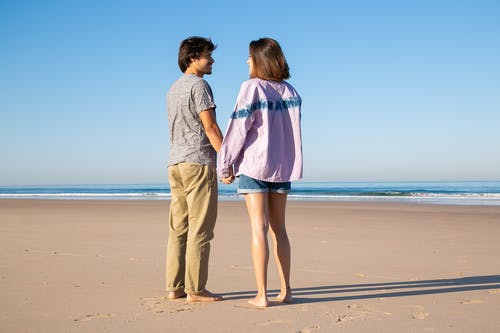 男人和女人站在海滩上 · 免费素材图片