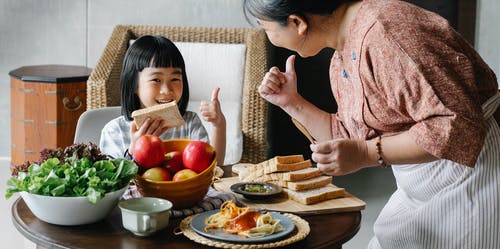 与孙女一起吃早餐的作物女人 · 免费素材图片