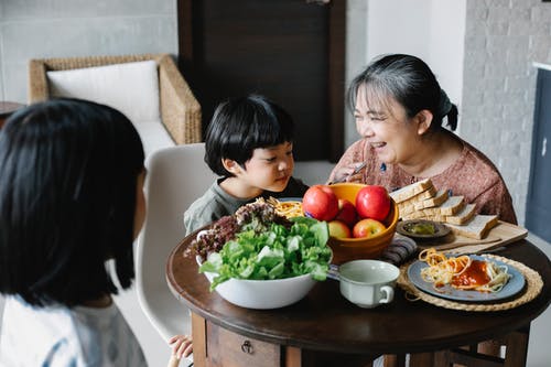 幸福的中年亚裔女子和孙子在家吃美味的早餐 · 免费素材图片