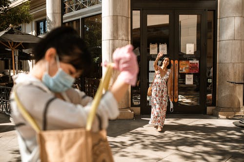 拿着棕色皮革手袋的白色和红色花裙子的女人 · 免费素材图片