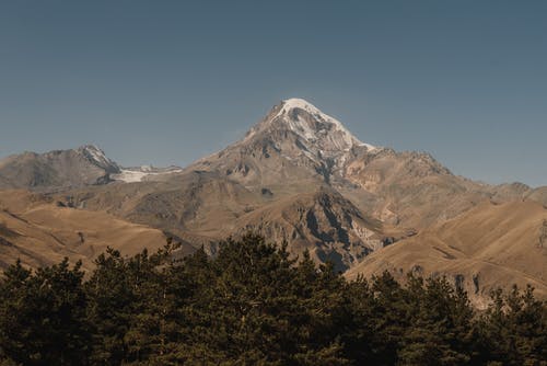 蓝蓝的天空下布朗山附近的绿树 · 免费素材图片