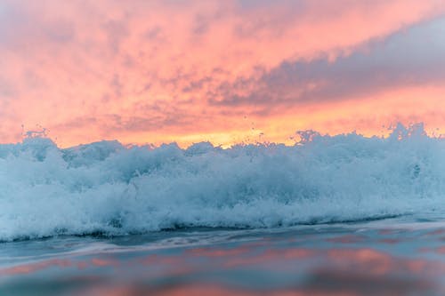 泡沫海在日落时色彩斑sky的天空下 · 免费素材图片