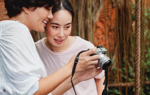 看照片照相机的屏幕愉快的亚裔妇女 · 免费素材图片