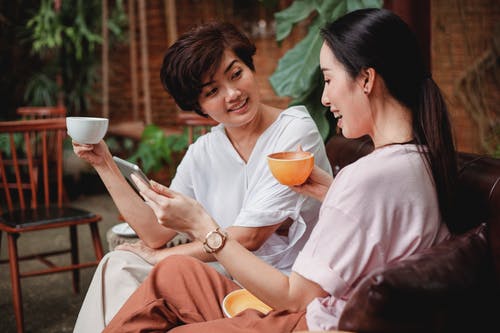积极的亚洲妇女在咖啡馆里喝咖啡 · 免费素材图片