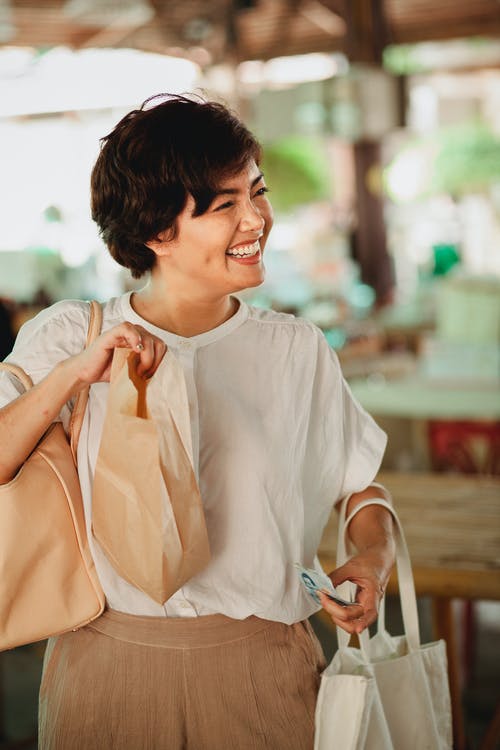有食物袋子的正面亚裔妇女在市场上 · 免费素材图片
