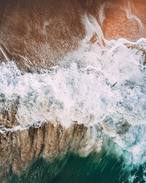 强大的泡沫波洗沙海岸 · 免费素材图片