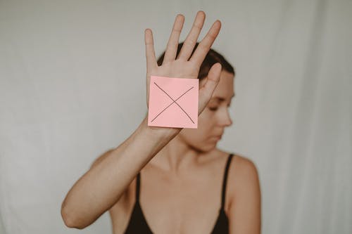 黑色意大利面条表带顶部拿着粉红色纸的女人 · 免费素材图片