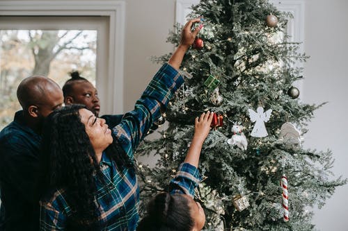 积极的黑人家庭装饰圣诞树 · 免费素材图片