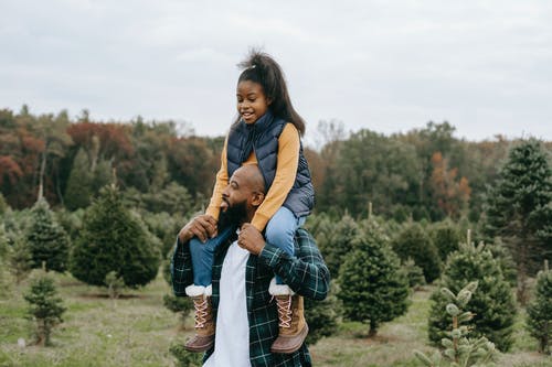 黑人父亲背着女儿在林场的肩膀上 · 免费素材图片