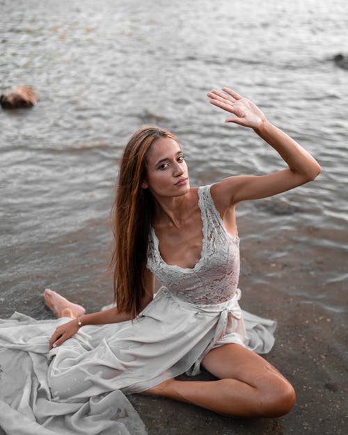 湿的白裙子，坐在沙滩上的优雅女人 · 免费素材图片