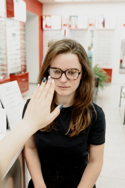 匿名的眼科医生在诊所检查女人的视力 · 免费素材图片
