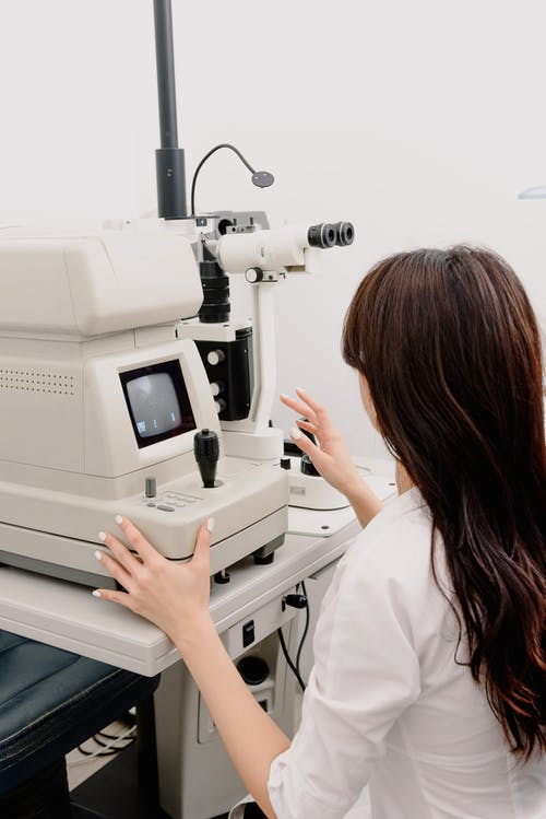 眼科医生在实验室中使用医疗机器 · 免费素材图片