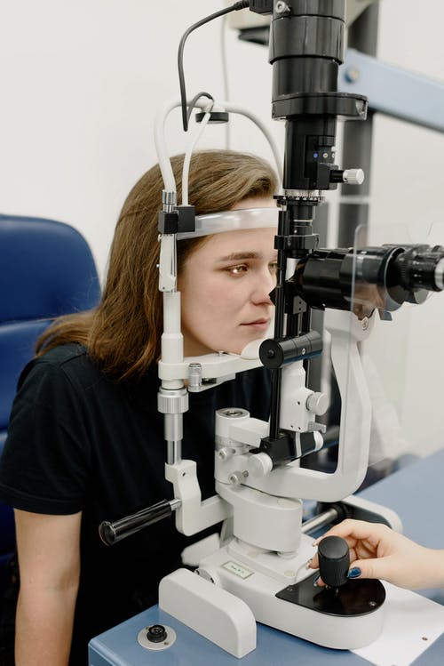 女人在诊所的机器上测试视觉 · 免费素材图片