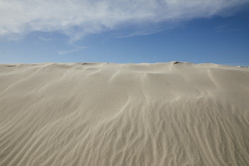 蓝多云的天空下的沙质沙漠 · 免费素材图片