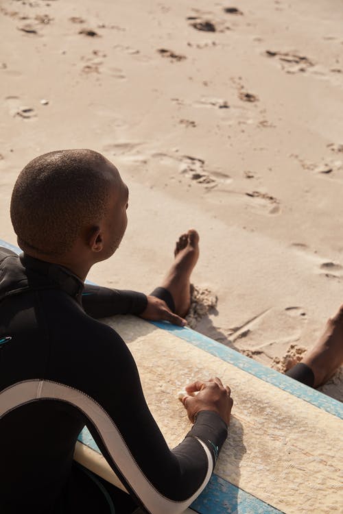 黑色的冒险家，在与冲浪板的沙滩上休息 · 免费素材图片