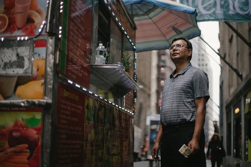 站在食品卡车附近的民族男子 · 免费素材图片