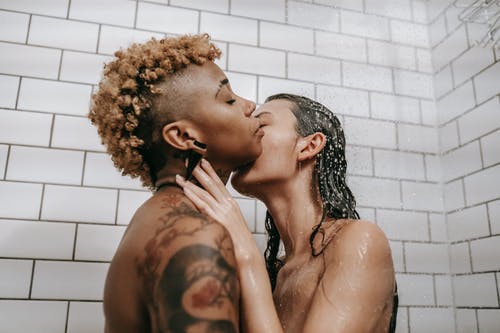 赤裸裸的女同性恋夫妇接吻在淋浴 · 免费素材图片