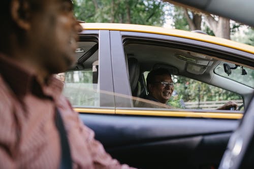 作物开朗开朗的出租车司机在车里说话 · 免费素材图片