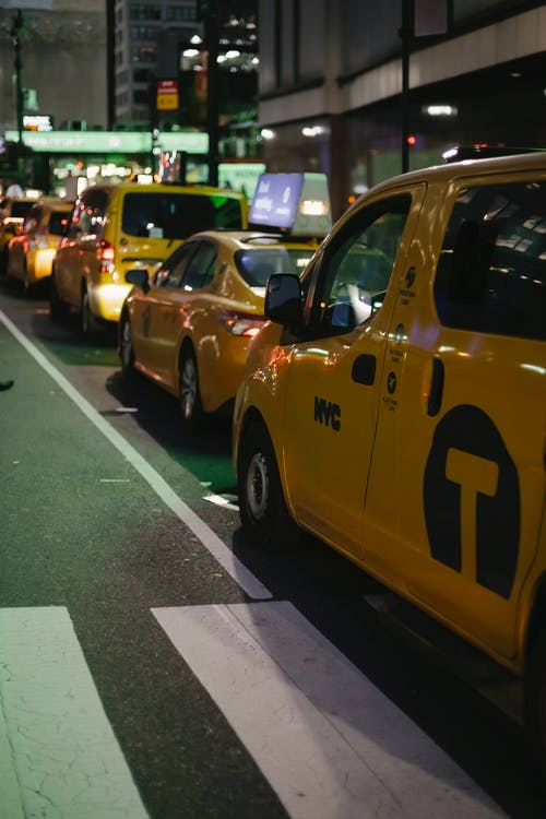 晚上路边停车的闪亮黄色出租车 · 免费素材图片