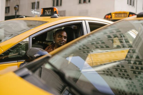 休息在城市的现代黄色汽车的民族出租车司机 · 免费素材图片