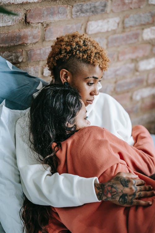 多种族的女同性恋者夫妇在床上拥抱 · 免费素材图片