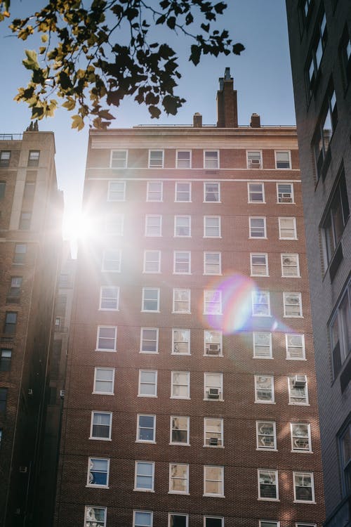 典型的多层住宅的外观与白色的窗户，在阳光明媚的日子 · 免费素材图片