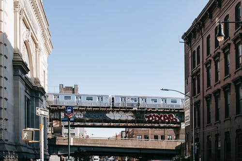 火车在街上的桥上的铁路上行驶 · 免费素材图片