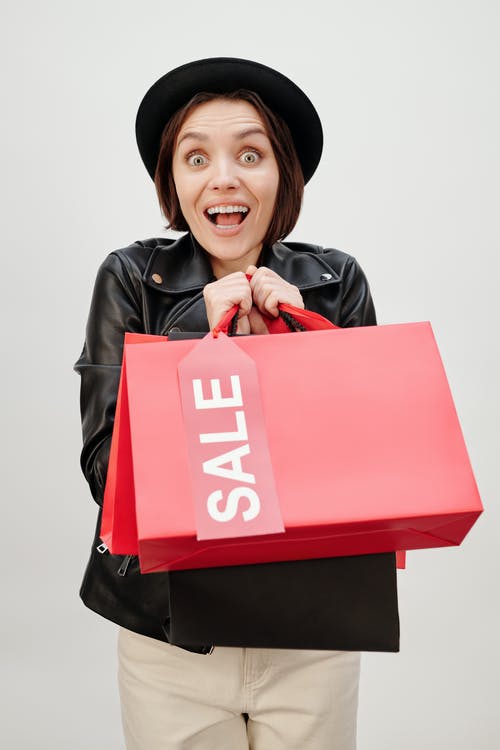 一个幸福的女人，拿着购物纸袋 · 免费素材图片