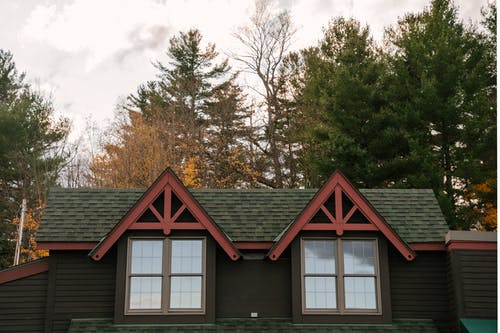 多云的天空位于秋天的树林中的老年住宅小屋的立面 · 免费素材图片