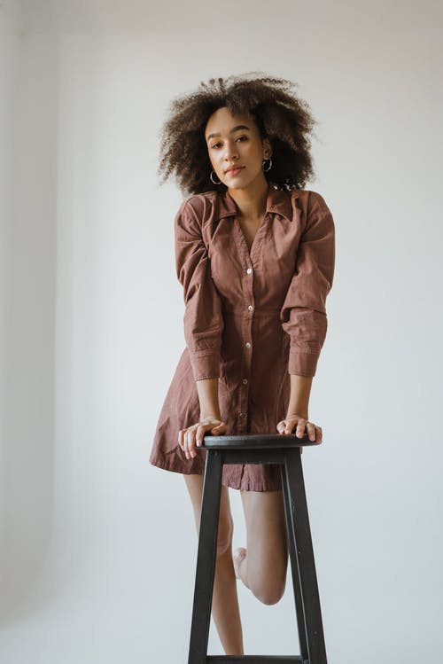 棕色皮夹克，坐在棕色的木椅上的女人 · 免费素材图片