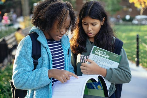 年轻的女学生在公园里的教科书 · 免费素材图片