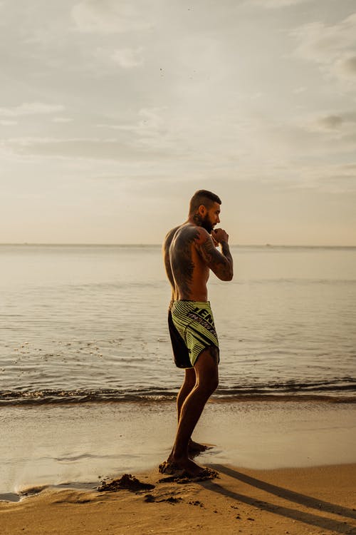 在海滩上运行的黑色短裤的男人 · 免费素材图片