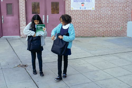 女学生背着背包一起离开学校 · 免费素材图片