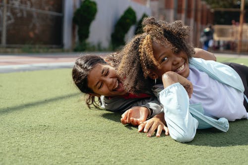 多族裔女友笑着在草坪上冷 · 免费素材图片