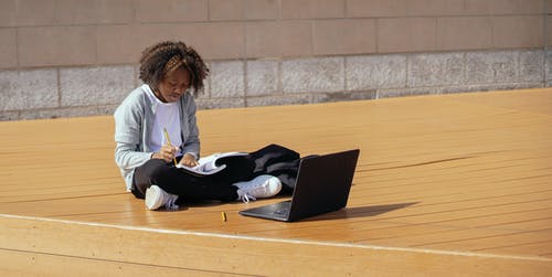 集中与笔记本电脑的黑人女孩 · 免费素材图片