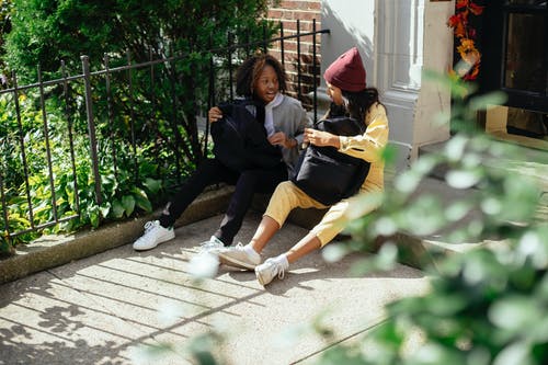 不同的女孩坐在篱笆旁聊天 · 免费素材图片