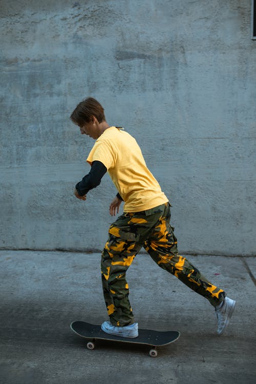 黄色的t恤和黑色和黄色的迷彩裤在路上跑的男孩 · 免费素材图片