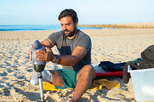 有胡子的人在海滩上戴腿假肢 · 免费素材图片