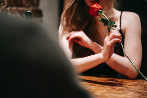 黑色背心抱着红玫瑰的女人 · 免费素材图片