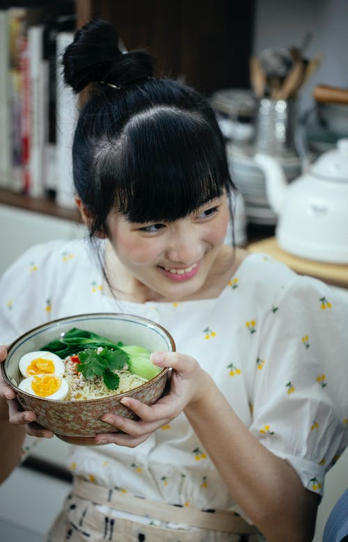 白色和黄色的花衬衫，拿着碗蔬菜沙拉的女孩 · 免费素材图片