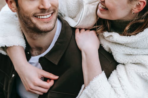 黑色西装外套的男人拥抱女人的白色皮大衣 · 免费素材图片