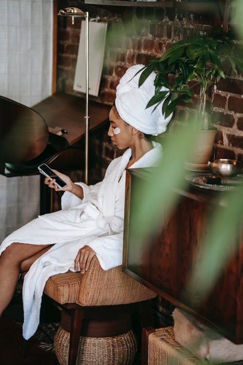 浴袍的种族妇女与在美容院的智能手机 · 免费素材图片