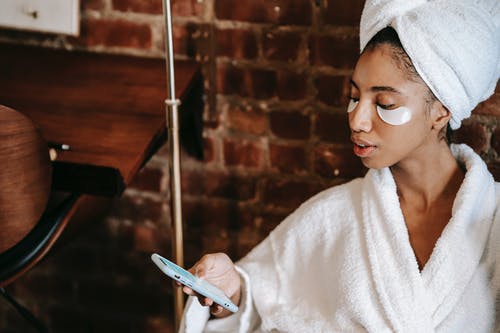 族裔女人触摸屏在美容院的智能手机上 · 免费素材图片