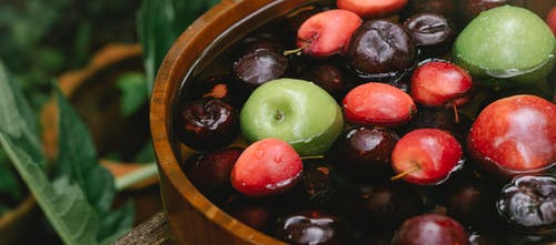 棕色碗里的绿色和红色圆形水果 · 免费素材图片
