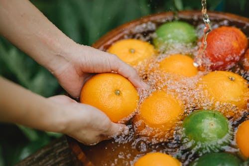 女人在淡水中清洗水果 · 免费素材图片