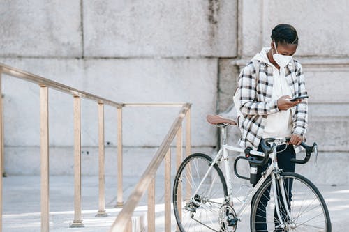 骑在自行车上的白色和棕色格子衬衫的男人 · 免费素材图片
