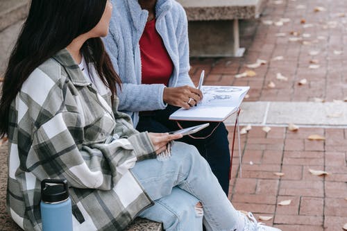 红色长袖衬衫阅读书中的女人 · 免费素材图片