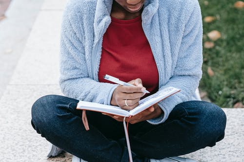 红色衬衫和灰色羊毛衫阅读书中的女人 · 免费素材图片